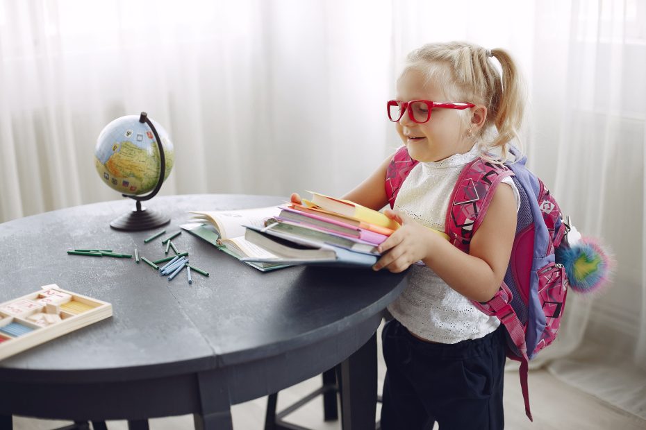 child putting away books